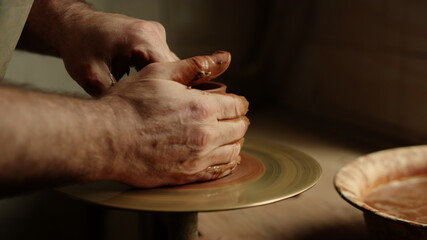 Artist sculpting clay product in pottery. Man producing new product in workshop