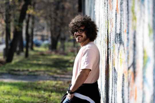 Attractive Man Posing at Graffiti Wall Outside