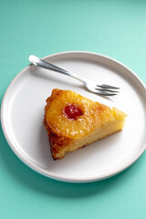 slice of pineapple upside down Cake with a fork on white plate 