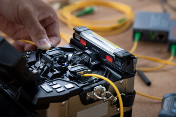 technician welding optical fiber cable with fusion splicing fiber optic Machine., pad cot cable