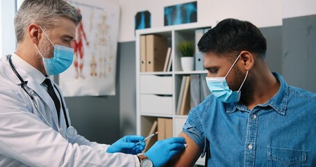 Close up portrait of experienced Caucasian middle-aged male specialist at work in quarantine doing...