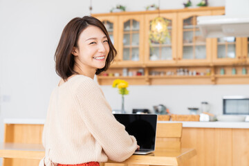 部屋でラップトップコンピューターを見る女性