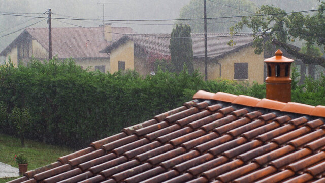 Pluie forte s'abattant sur les toitures des maisons d'un village, dans le Sud-Ouest de la France