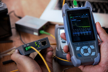 master's hands with optical fiber tester after Fusi, OTDR meter