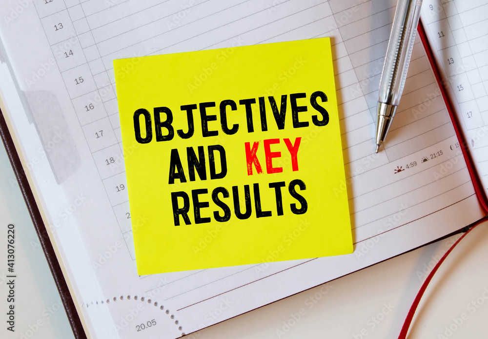Poster objective key results okr text in the office notebook. view from above