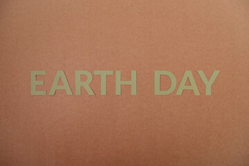 Earth Day green cardboard letters on a craft paper