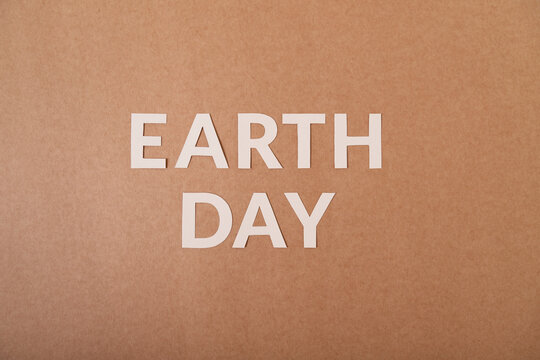Earth Day white cardboard letters on a craft paper
