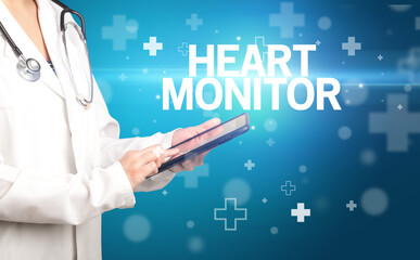 doctor writes notes on the clipboard with HEART MONITOR inscription, first aid concept