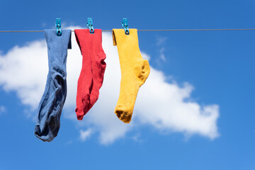 Yellow, red and blue socks hanging for outdoor drying. colored socks.