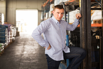 Portrait of man near forklift in gardening section of hypermarket
