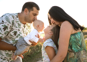 family in a field walking at sunset