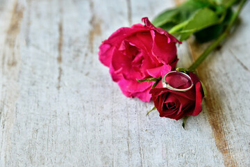 Rose flowers with ring on wooden backgrounds.