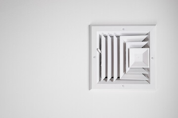 Photograph of a residential ceiling heating and cooling vent painted white