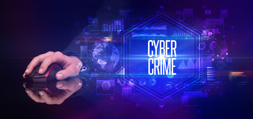 hand holding wireless peripheral with CYBER CRIME inscription, cyber security concept