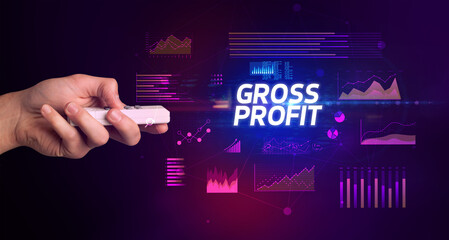 hand holding wireless peripheral with GROSS PROFIT inscription, cyber business concept
