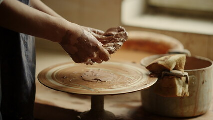 Unknown lady getting ready to make product in pottery. Hands modeling clay