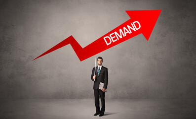 Obraz premium Young business person in casual holding road sign with DEMAND inscription, business direction concept