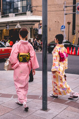 Beautiful girls with traditional and colorful kimonos walking in the downtown streets of Kyoto, Japan