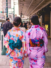 Beautiful girls with traditional and colorful kimonos walking in the downtown streets of Kyoto, Japan
