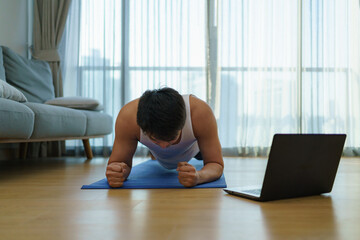 Asian men exercise at home by planking in gym closures during COVID-19 outbreak.