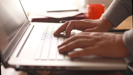 Close up of person fingers typing on laptop, business or education