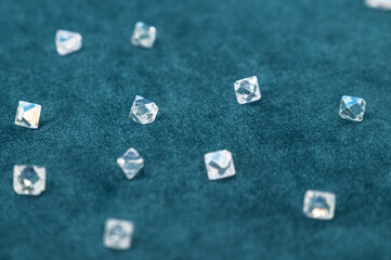 Several large faceted diamonds lie on the blue velvet. Close-up photo