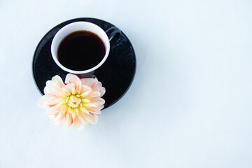 ダリアの花と黒いコーヒーカップに入れたコーヒー花とコーヒー