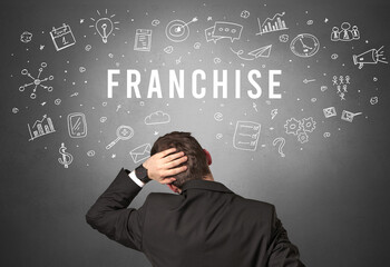 Rear view of a businessman with FRANCHISE inscription, modern business concept