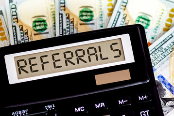 Calculator with text REFERRALS on the dollars. Business, finance conceptual.