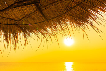 Fototapeta na wymiar Umbrella and chair around outdoor swimming pool with sea beach ocean at sunset