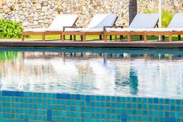 Empty deck chair around outdoor swimming pool