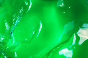 Cosmetic lotion gel green background. Cosmetic concept. Liquid gel cosmetic smudge drops texture. Flat style, top view.