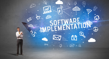 Businessman defending with umbrella from SOFTWARE IMPLEMENTATION inscription, modern technology concept