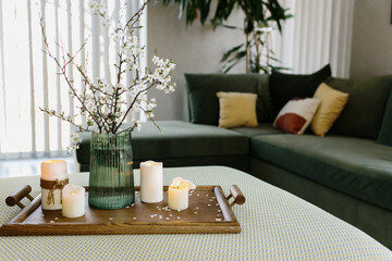Home interior. Relaxing candles. Apple tree color has flown. Blurred background
