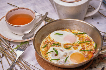 Lunch food recipes omlette, in portioned skillet, on white stone table