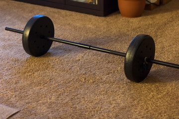 Obraz na płótnie Canvas Bench press style weights on a brown carpet ready for at home workout.