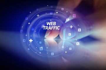 Finger touching tablet with social media icons and WEB TRAFFIC