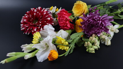 Close up. Beautiful bouquet of blooming colorful bright flowers isolated in dark background. 