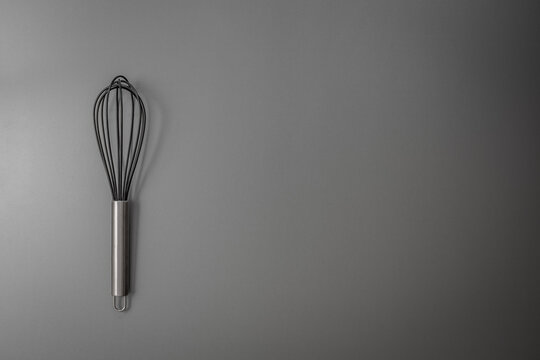 Silicone whisk on black background, Food tool background, Top view.