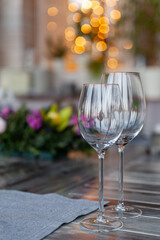 Modern veranda restaurant interior, flowers, banquet setting, glasses, plates