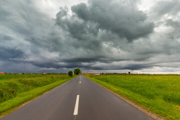Beautiful rural fields in spring, under dramatic stormy sky
