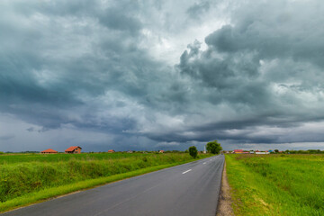 Beautiful rural fields in spring, under dramatic stormy sky