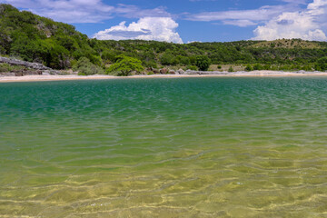 Pedernales Falls State Park in Texas with emerald green geological rock pools of water trapped by the the limestone riverbed as thunderclouds form in over the rolling central Texas Hill Country