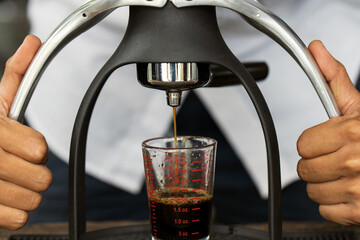 Obraz premium Brista making a cup of coffee with manual espresso coffee maker.