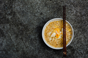 Instant noodles with egg on natural dark background
