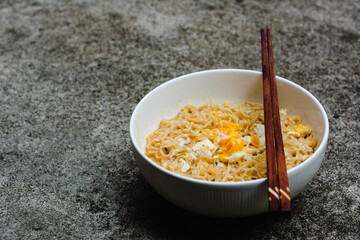 Instant noodles with egg on natural dark background