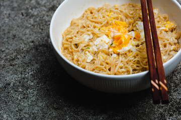 Instant noodles with egg on natural dark background