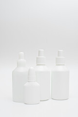 White plastic bottles of medicines on neutral background
