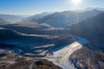 Backlight aerial view of confluence of Chuya river with Katun river on sunny winter day. Altai...