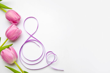 Figure 8 made of violet ribbon and tulip flowers on light background. International Women's Day celebration